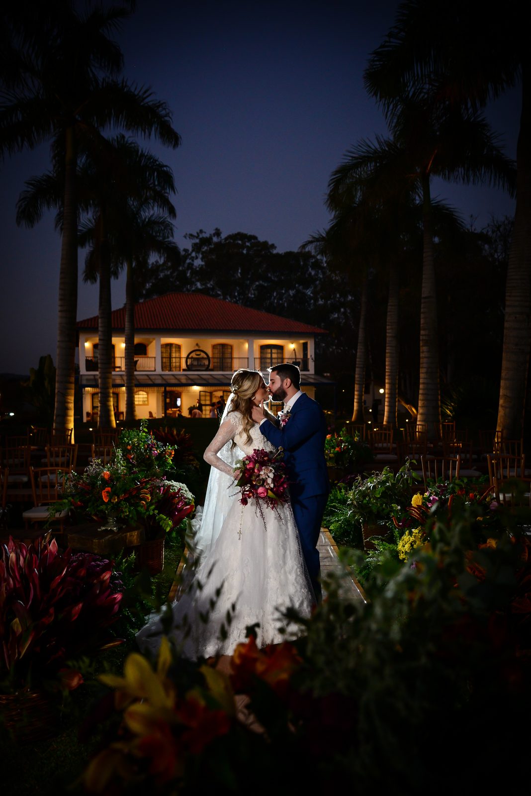 Casal de noivos à noite no jardim iluminado de casarão colonial